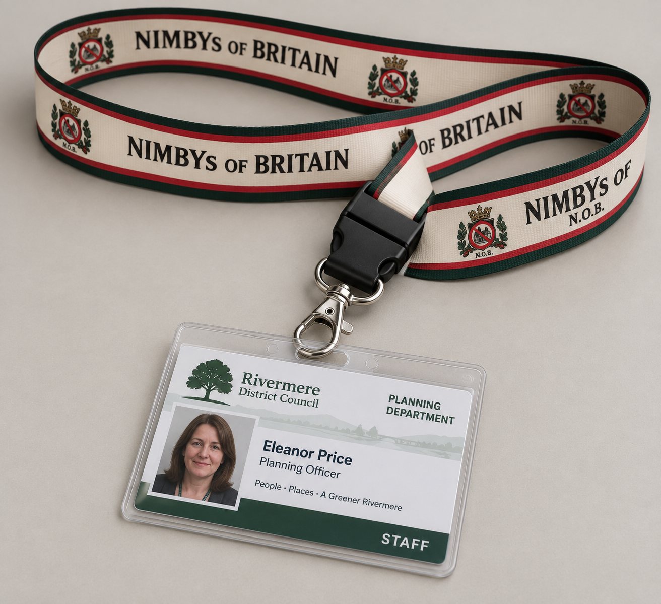 A woven cream lanyard printed with NIMBYs of Britain and the arms, with green and red edges, a black safety clip and a metal hook, holding a district council planning officer's staff pass